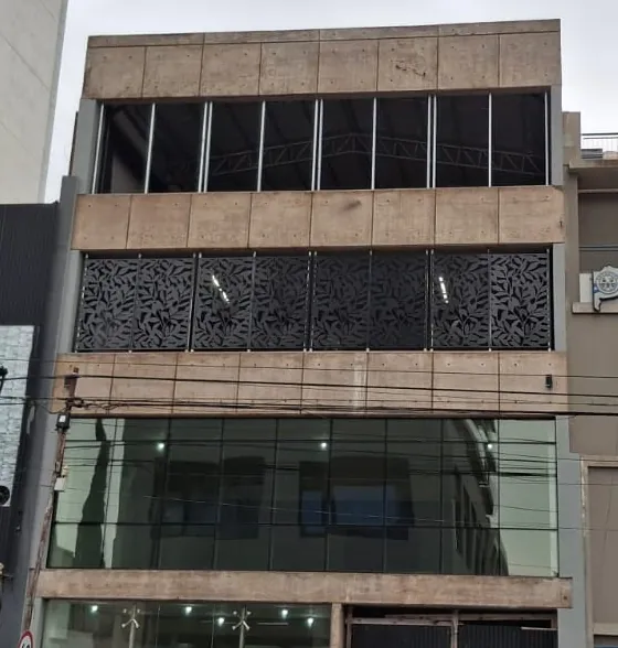 Frente de edificio con paneles metálicos calados negros